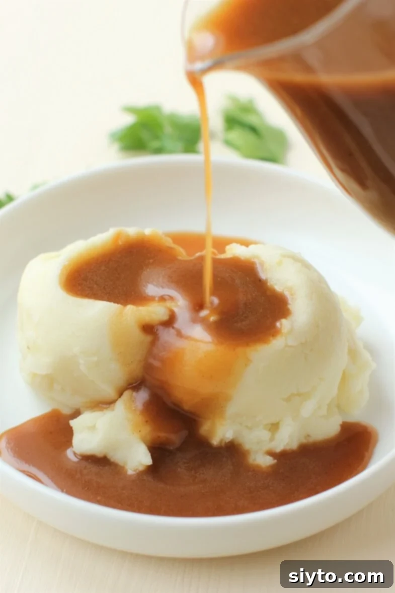Rich gluten-free turkey gravy being poured over mashed potatoes, ready for a stress-free holiday meal