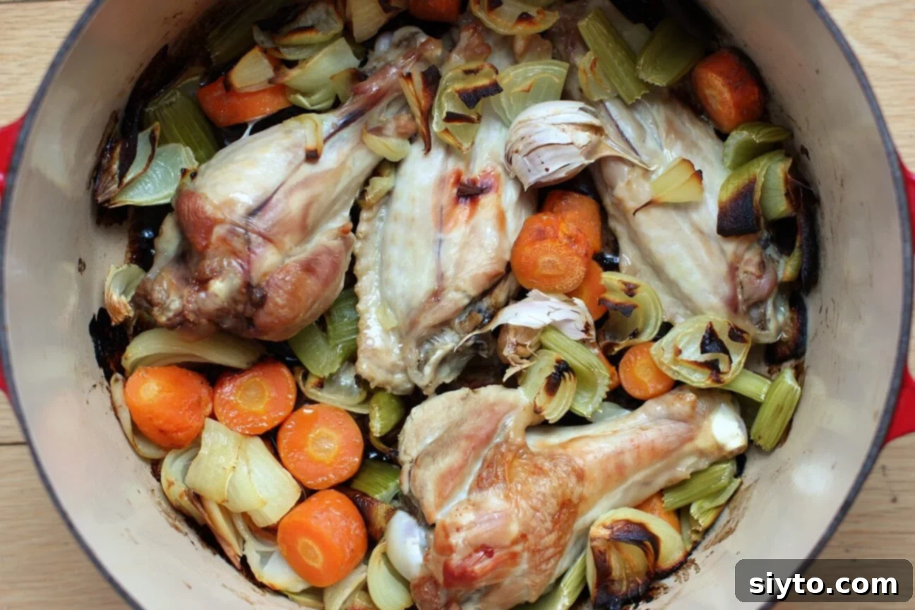 Roasted turkey wings and deeply caramelized vegetables in a pot after roasting, crucial for rich gravy flavor