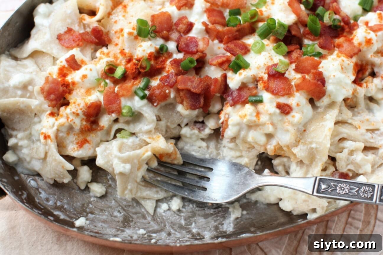A serving dish of Túrós Csusza, partially eaten, with a humorous caption wondering who started before it was served.