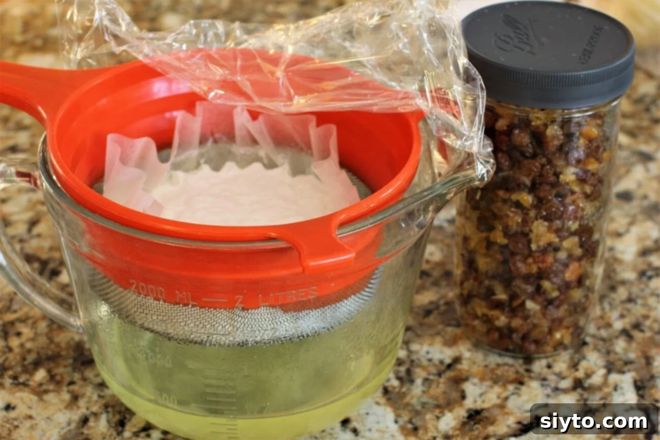 Quarkstollen: The Quicker German Christmas Cake 4 yogurt straining in strainer and raisins and peel in a jar