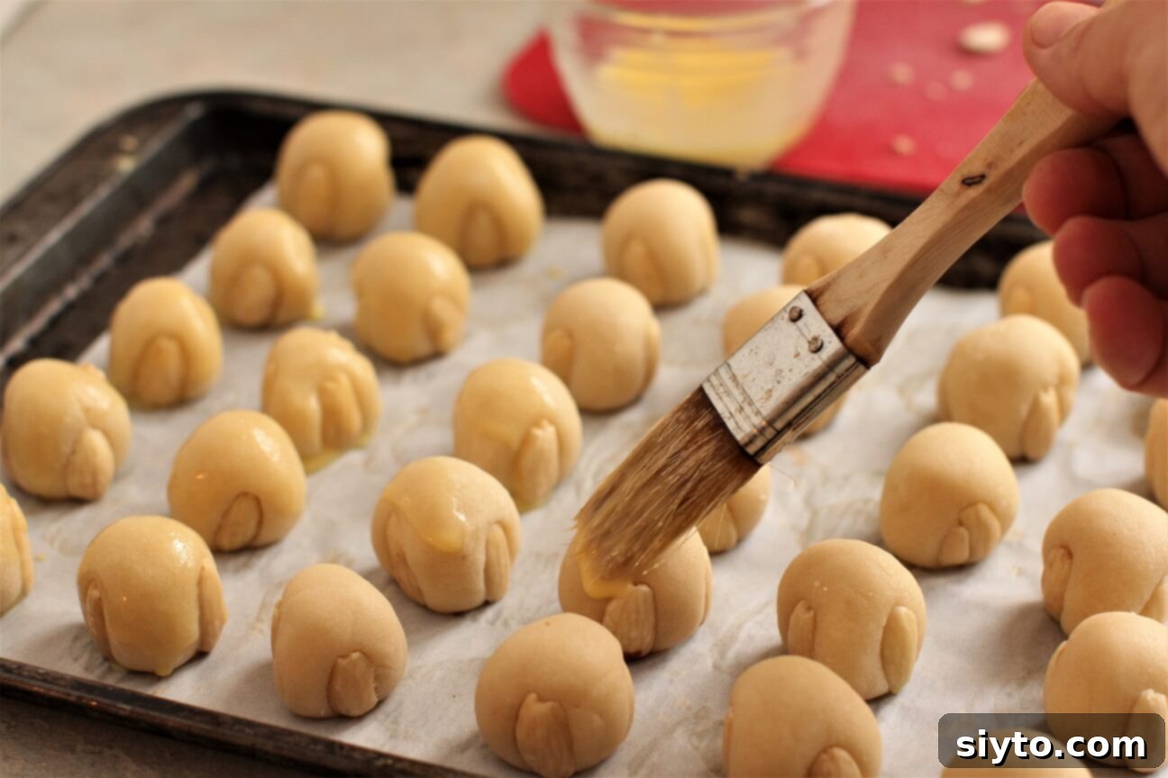 brushing the cookies with an egg yolk wash