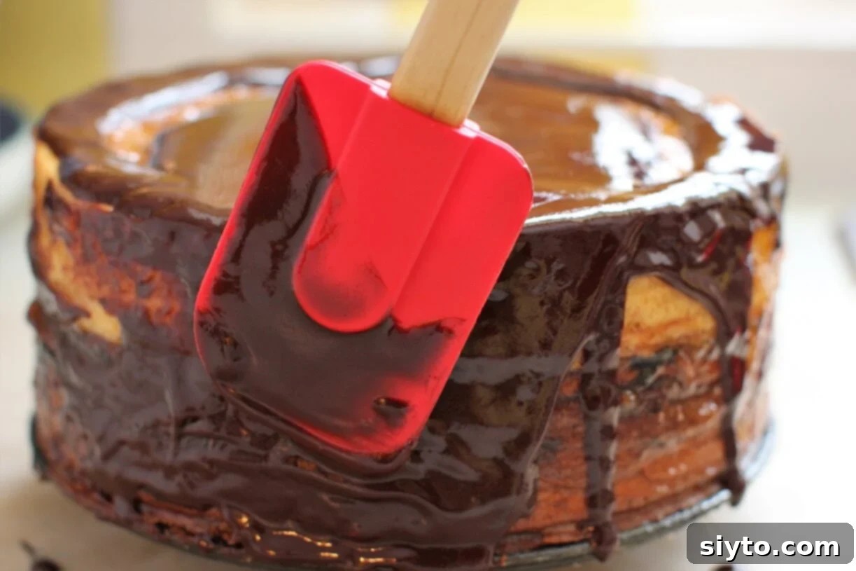 spreading the chocolate glaze on the cake