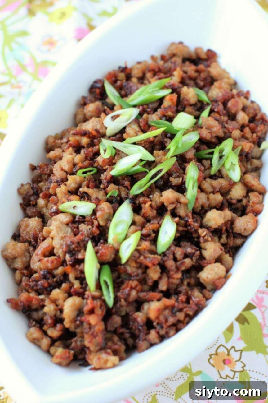 A heaping bowl of Vietnamese caramelized pork, garnished with fresh herbs and peanuts, ready to be served over rice