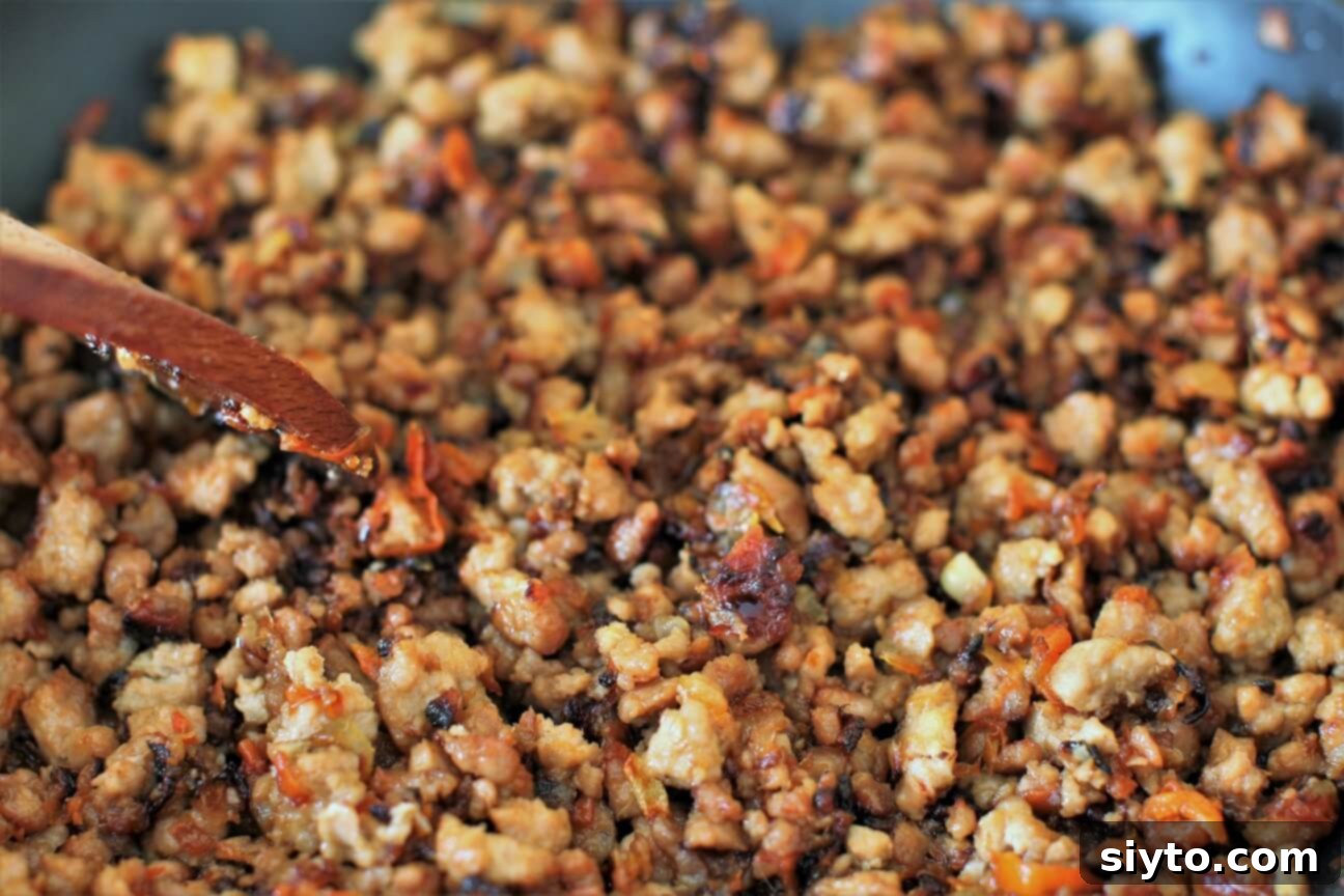 Skillet of ground pork that's fully caramelized, showcasing crispy, sticky pieces
