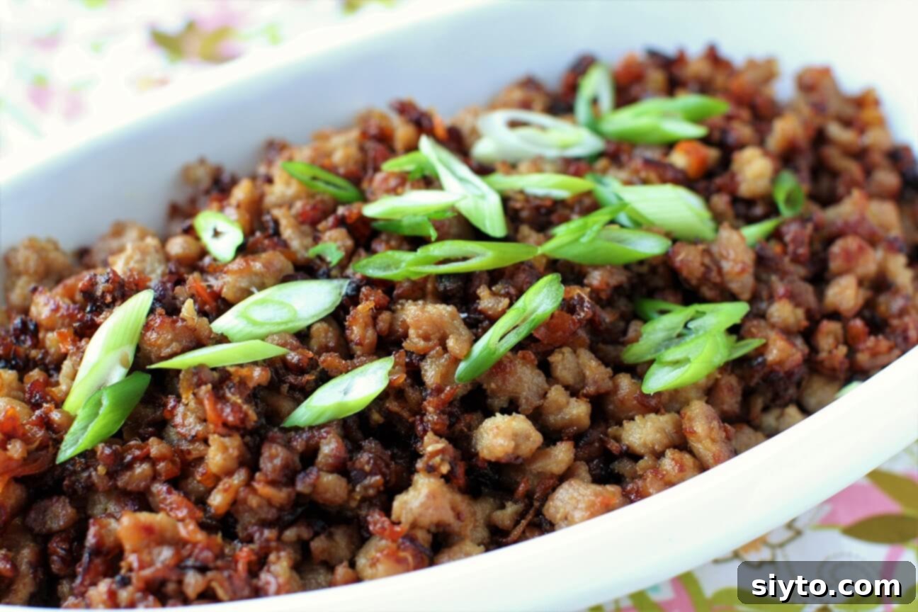 Bowl of Vietnamese caramelized pork garnished with fresh sliced green onions