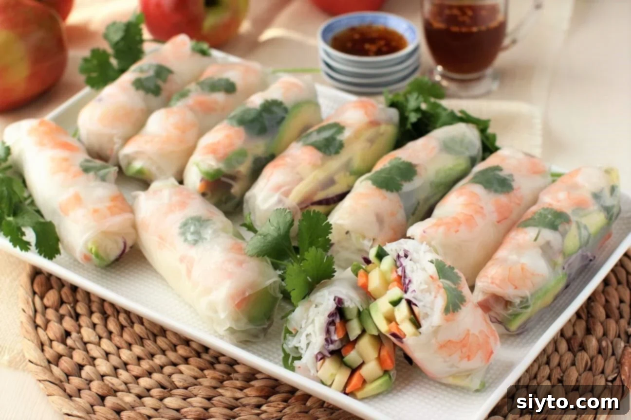 A pristine white platter elegantly showcasing numerous freshly prepared apple and shrimp summer rolls, highlighting their clean and appetizing presentation.
