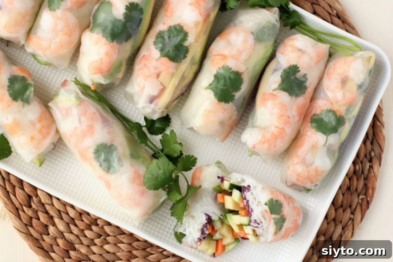 An inviting overhead view of a platter filled with freshly made Apple and Shrimp Summer Rolls, ready for dipping and enjoying.