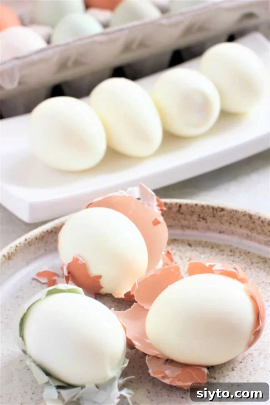 easy peel boiled eggs, 3 eggs partially shelled on plate