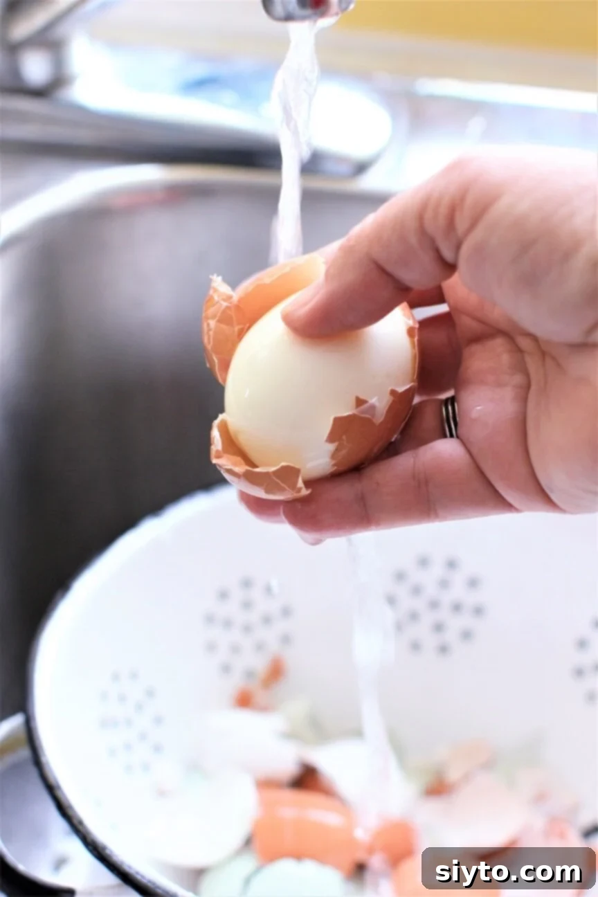 peeling an egg under running water