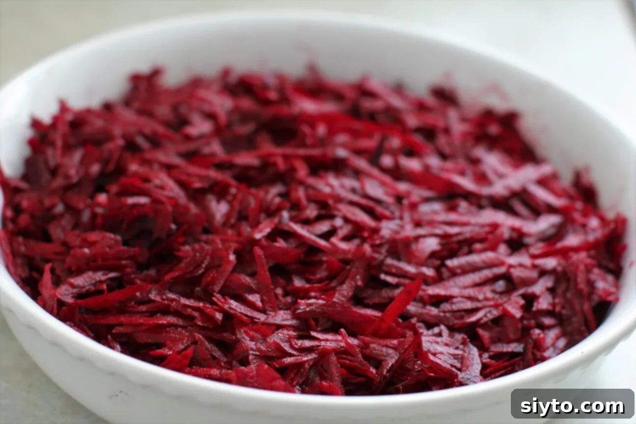 Freshly shredded beets showcasing their vibrant, jewel-like magenta color, ready for baking into a gratin.