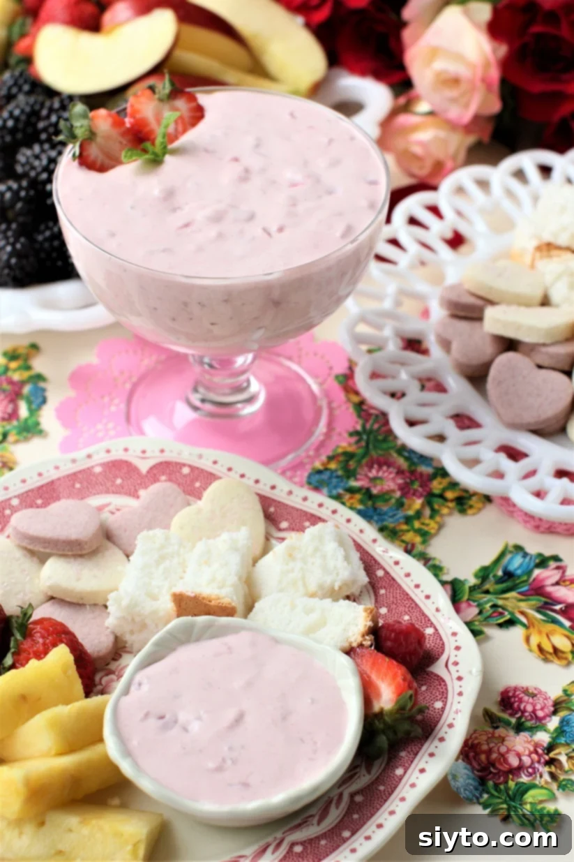dish of strawberry fruit dip and plate with fruit, cookies, and cake for dipping
