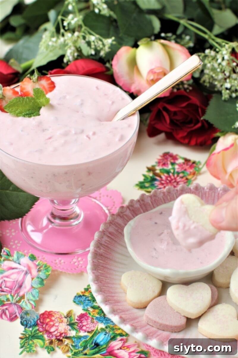 dipping a heart cookie into the fruit dip