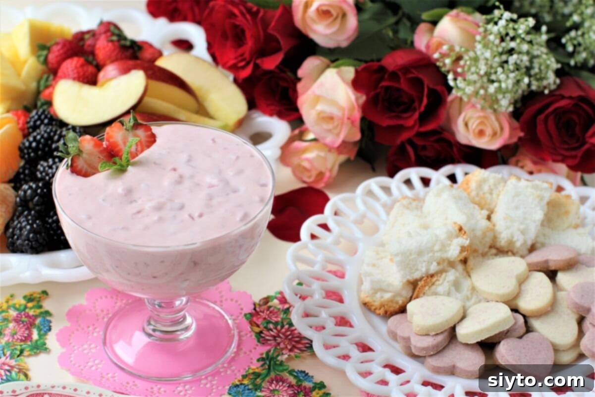 fruit dip in a footed dish beside a plate of heart cookies and cake cubes