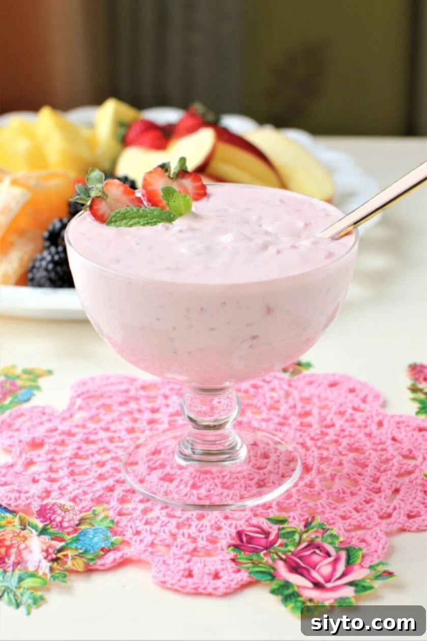 strawberry fruit dip in a footed glass bowl on a pink doily