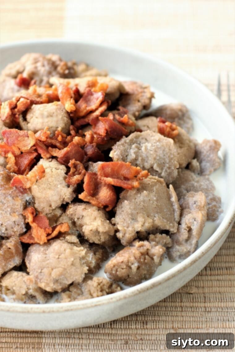 A plate of Stäerzelen, buckwheat dumplings, served with crispy bacon and a drizzle of warm milk, highlighting their rustic charm and appetizing presentation.