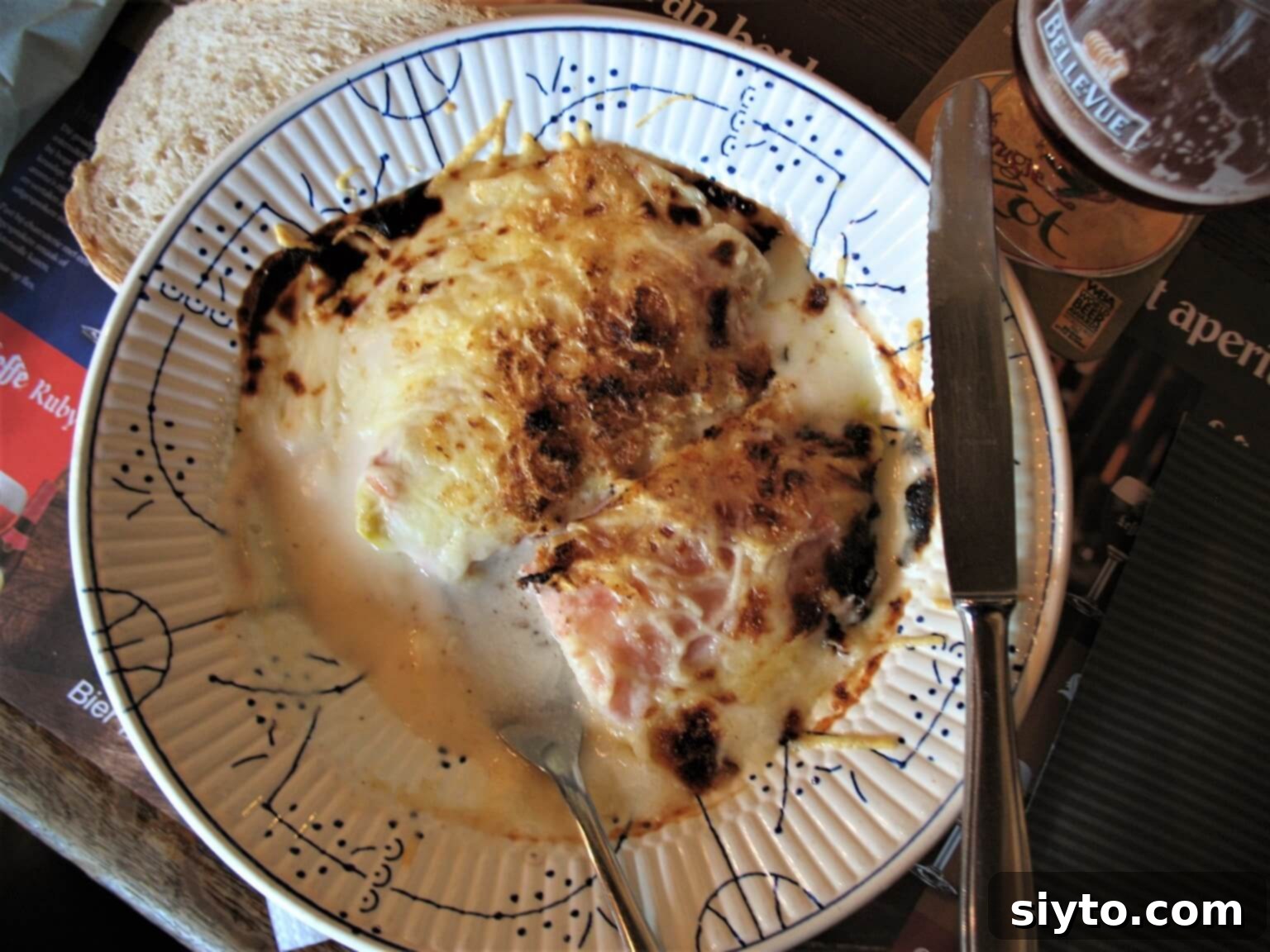 Chicons au Gratin: A Taste of Our Belgian Journey 3 A Belgian plate featuring golden-brown braised endive au gratin, crispy at the edges, served with crusty bread