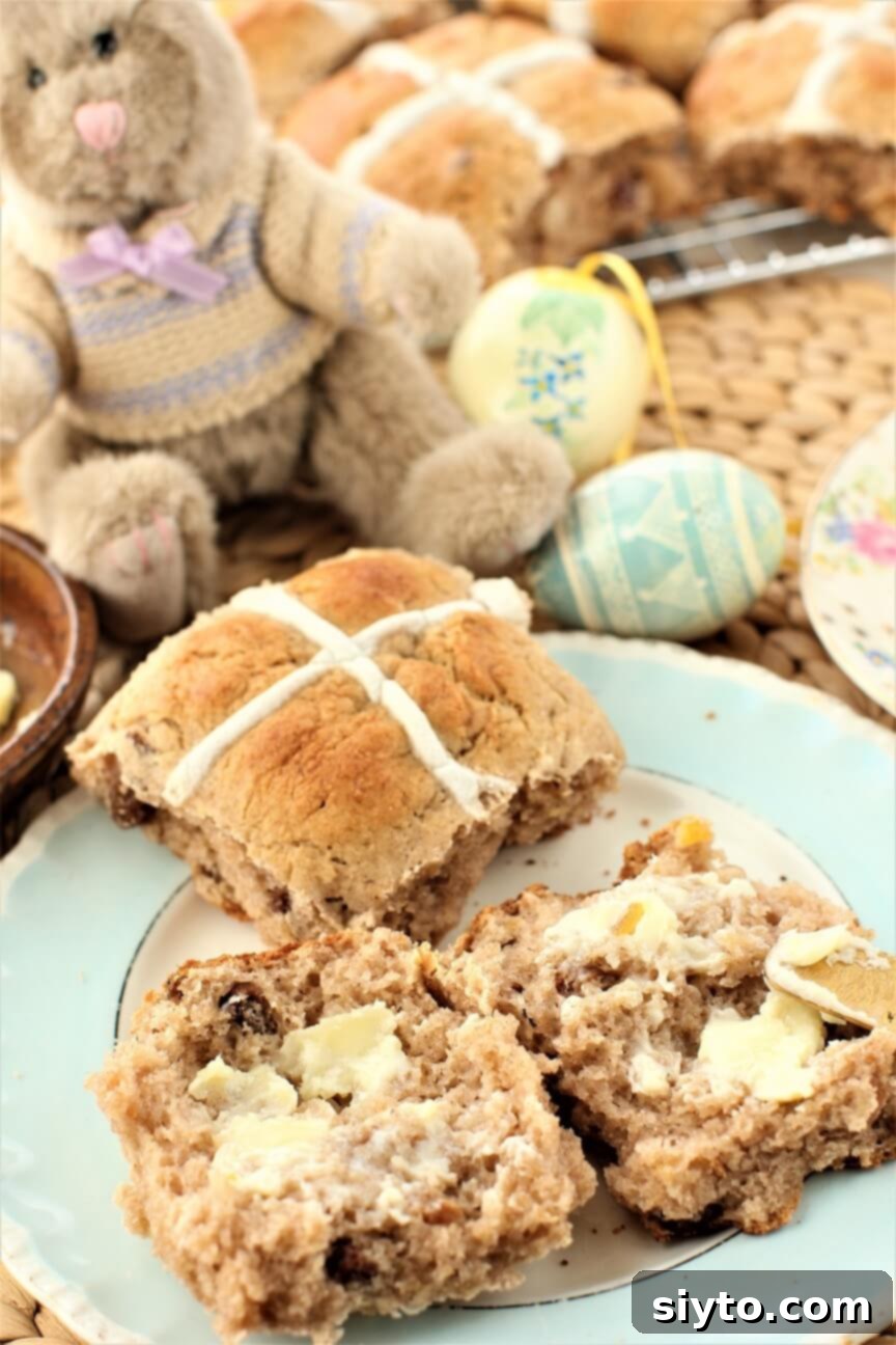 Fluffy Gluten-Free Hot Cross Buns 2 Stuffed bunny with a plate of golden-brown gluten-free hot cross buns, ready for Easter