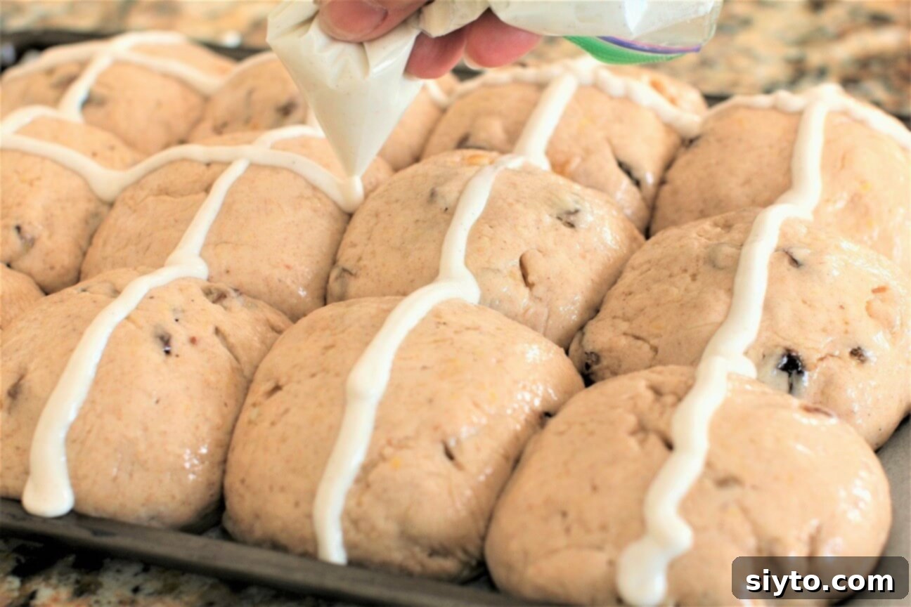 Fluffy Gluten-Free Hot Cross Buns 11 Piping the traditional cross onto gluten-free hot cross buns using a simple flour paste