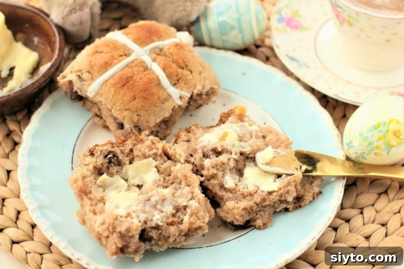 Fluffy Gluten-Free Hot Cross Buns 15 A close-up of a split gluten-free hot cross bun served with melting butter, showing its texture and deliciousness