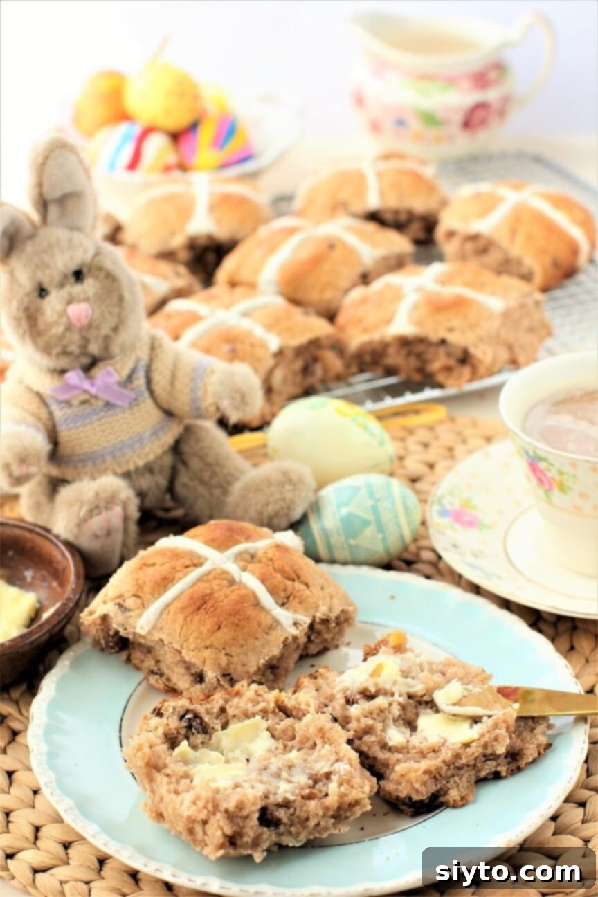 Fluffy Gluten-Free Hot Cross Buns 4 A charming stuffed bunny guarding a plate of freshly baked gluten-free hot cross buns, adding a festive touch