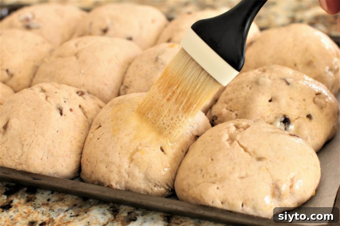 Fluffy Gluten-Free Hot Cross Buns 10 Brushing risen gluten-free hot cross buns with a sweet egg glaze to prepare them for baking