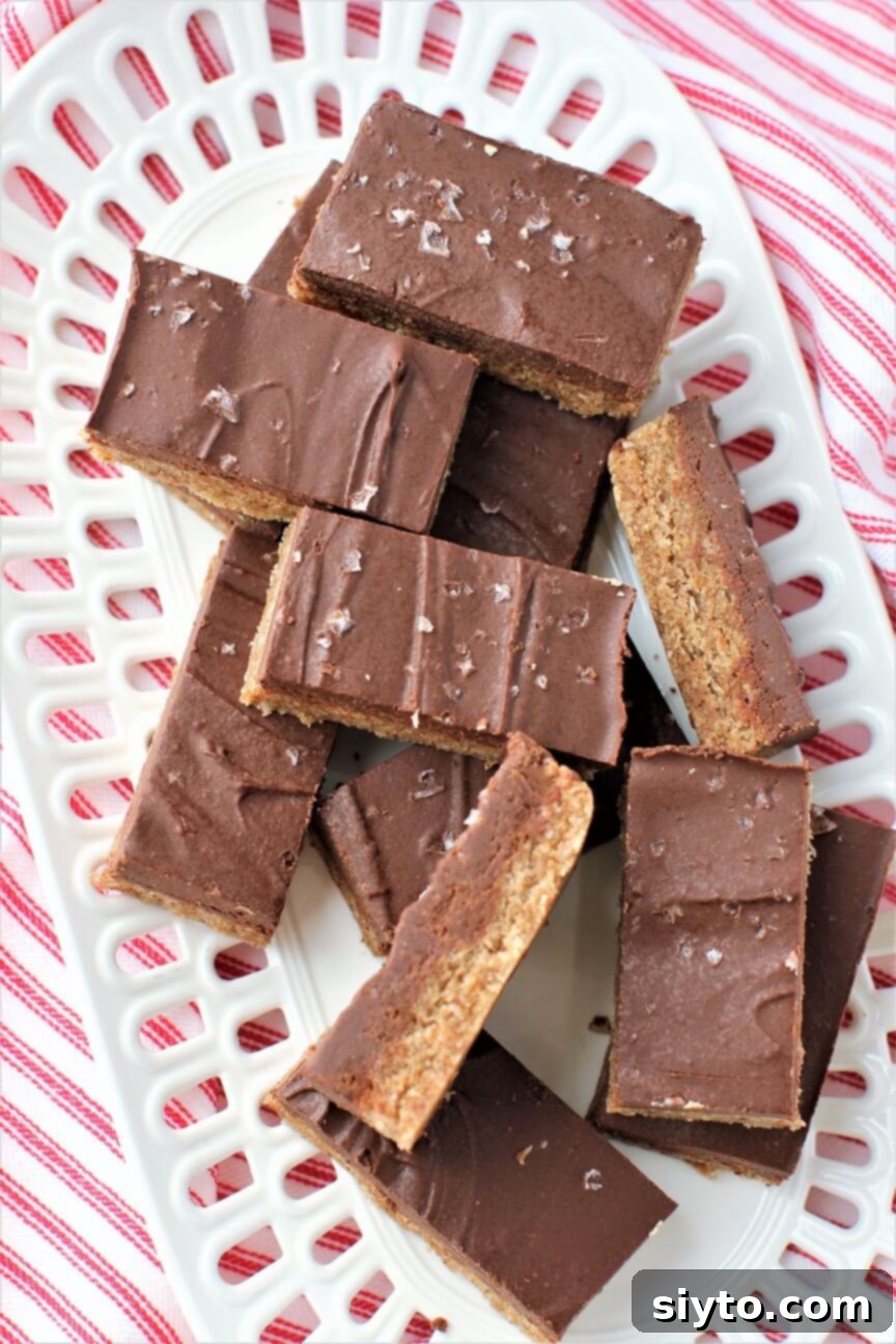 A few No-Bake Chewy Chocolate Almond Bars turned sideways, revealing the distinct chewy base and thick, fudgy chocolate top layer.