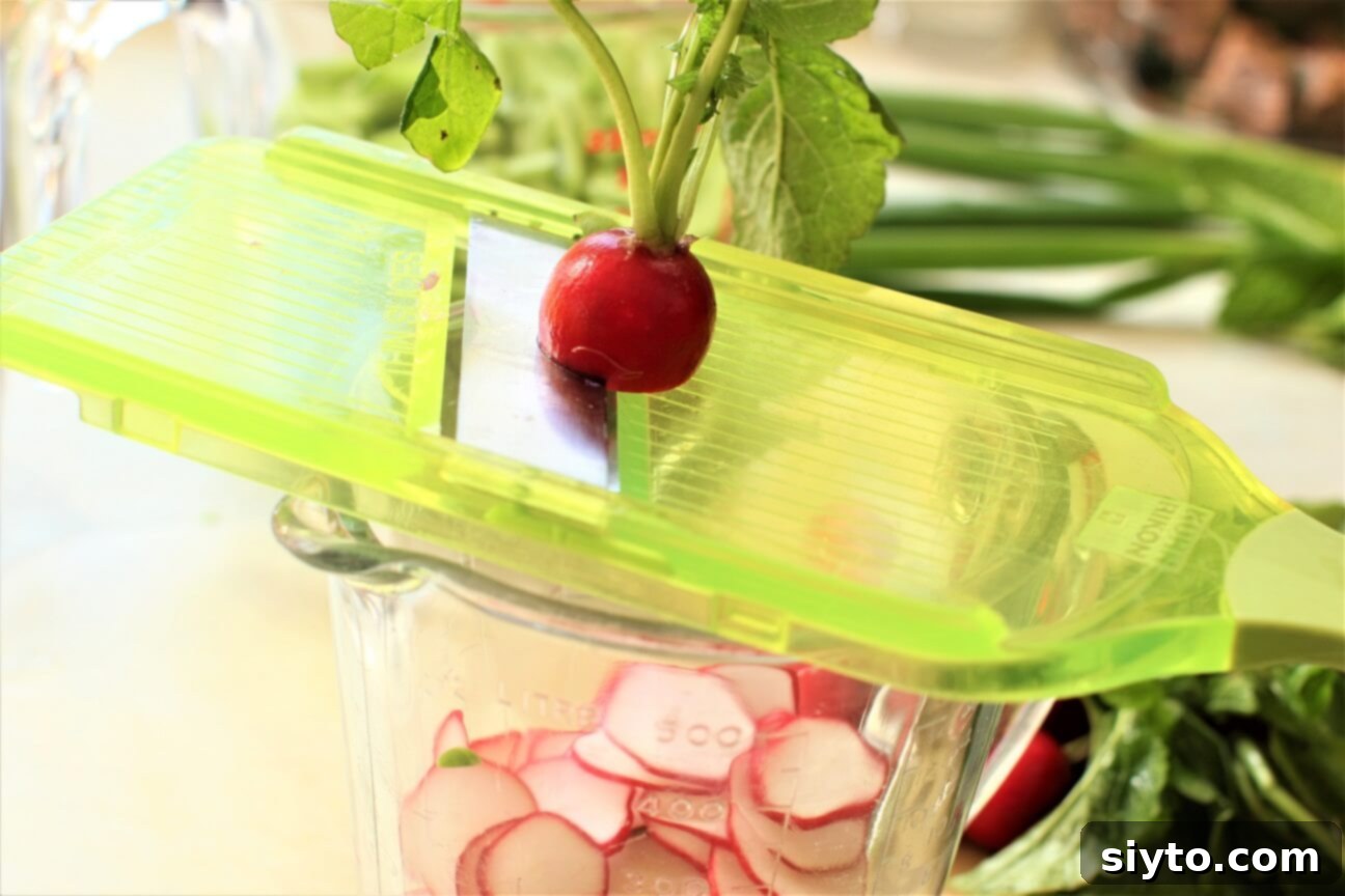 Snap Pea and Radish Salad: A Taste of Spring 9 Close-up shot of a mandolin being used to thinly slice red radishes, with a few already sliced radishes visible.