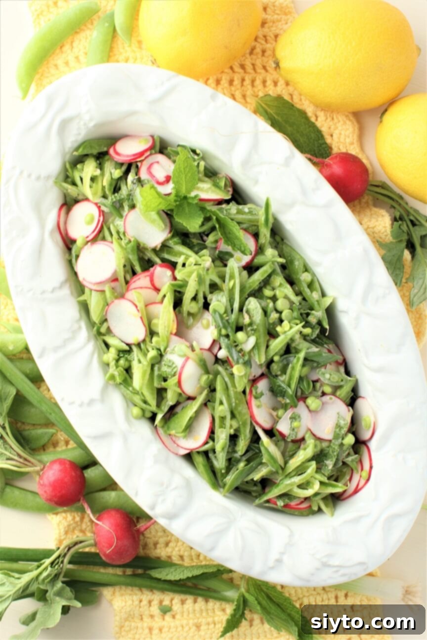Snap Pea and Radish Salad: A Taste of Spring 10 An oval white bowl filled with the freshly prepared snap pea & radish salad, glistening with its light dressing and vibrant colors.