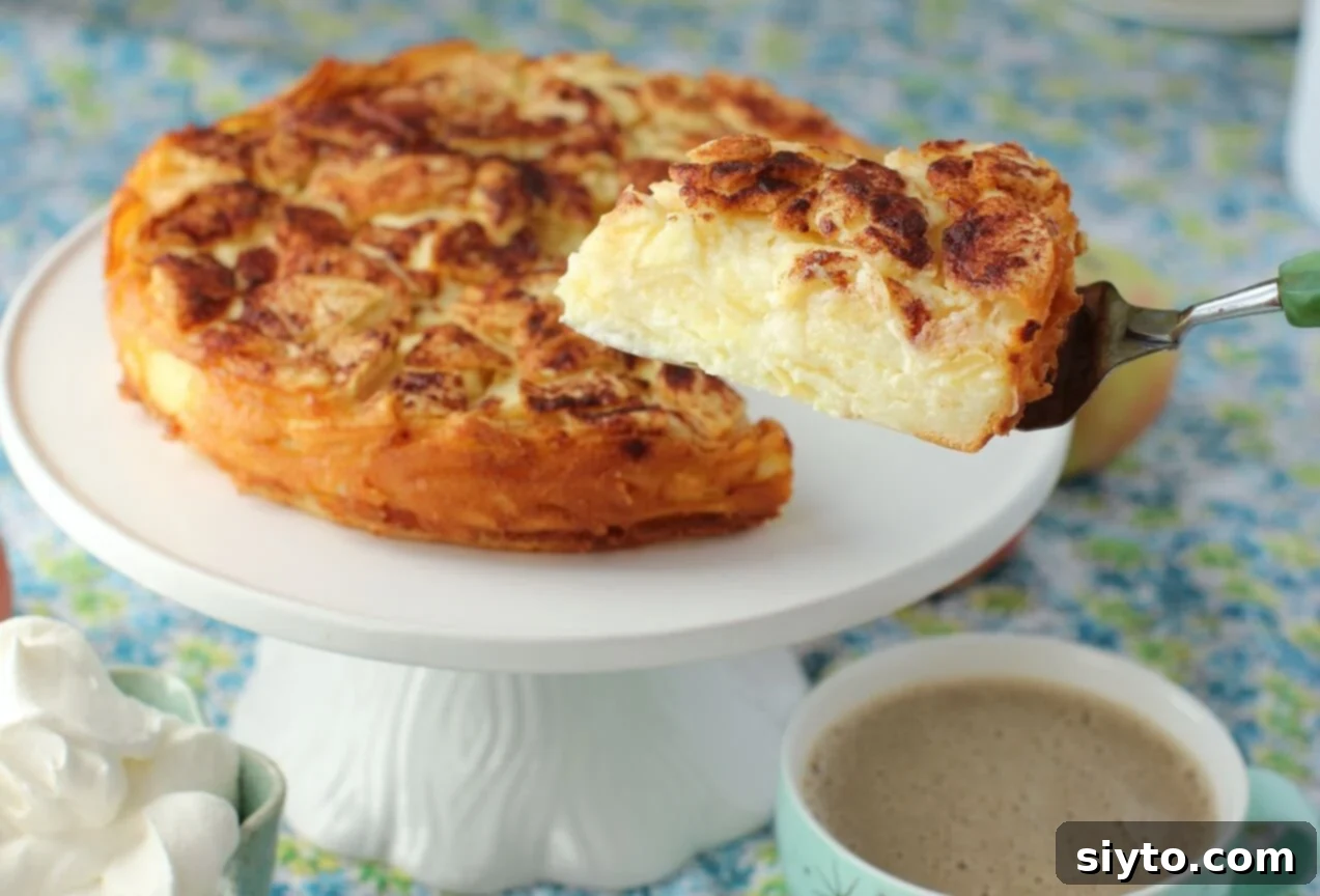 German Crustless Apple Pie: Creamy and Bursting with Apples 13 lifting a slice of apple pie on a cake server