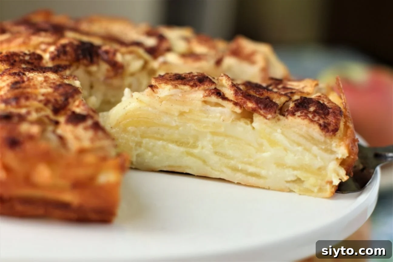 German Crustless Apple Pie: Creamy and Bursting with Apples 6 cutting a slice of the crustless apple pie