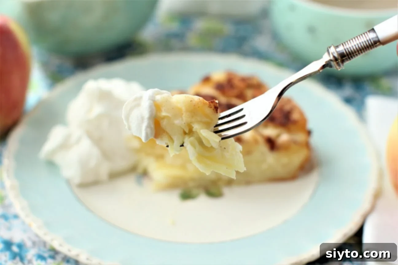 German Crustless Apple Pie: Creamy and Bursting with Apples 7 a forkful of crustless apple pie with a dollop of whipped cream