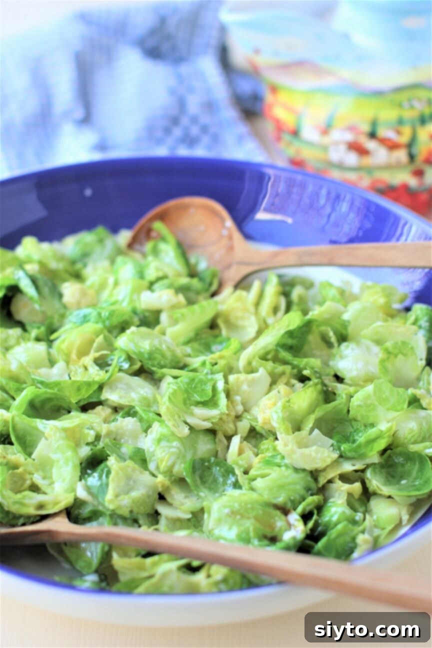 A large shallow bowl filled with beautifully prepared warm Brussels sprout salad, ready for serving