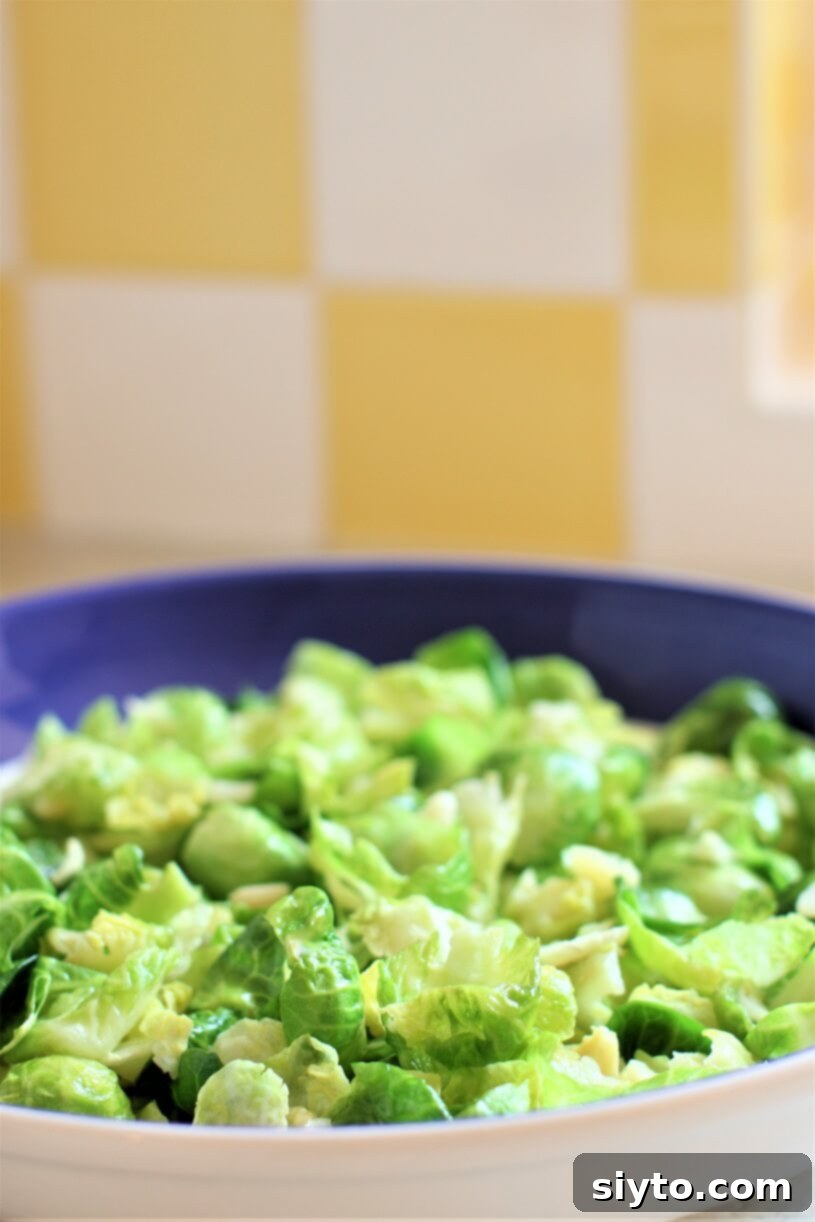 A bowl filled with freshly steam-sautéed Brussels sprout leaves, perfectly bright green and tender
