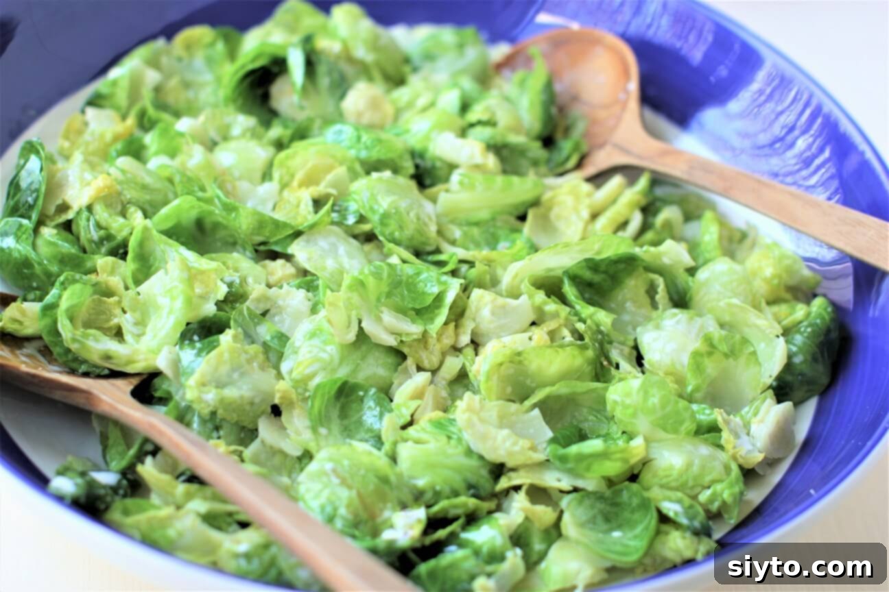 Close-up view of the warm Brussels sprout salad, showcasing the tender leaves coated in creamy dressing