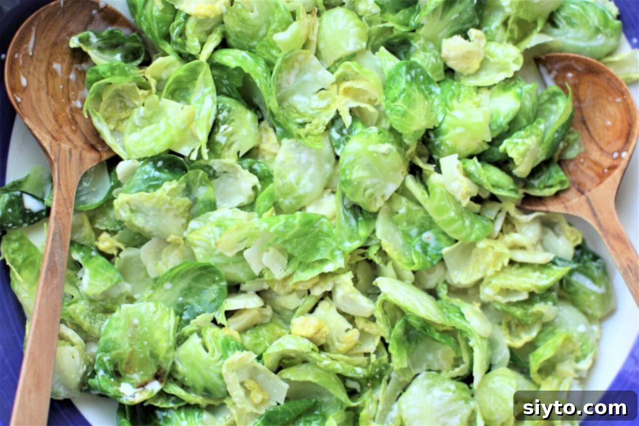 Top-down close-up shot of the tender Brussels sprout leaves, perfectly coated with the creamy dressing