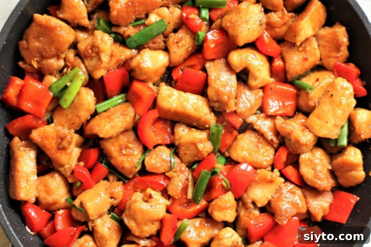 meat chunks in the pan with peppers and green onions