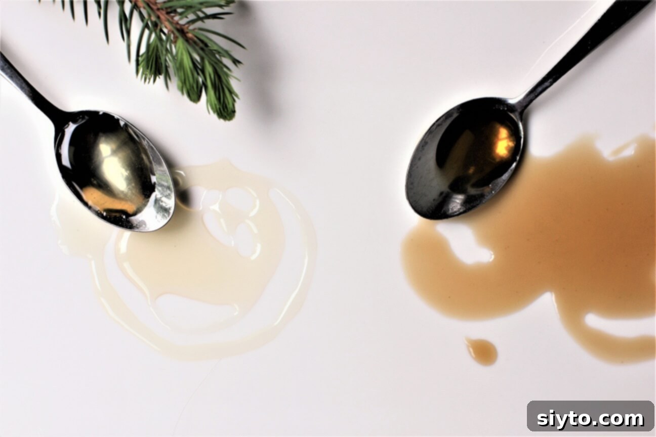 A smear of cooked and raw spruce tip syrups on a white board with spoons, showcasing their color difference