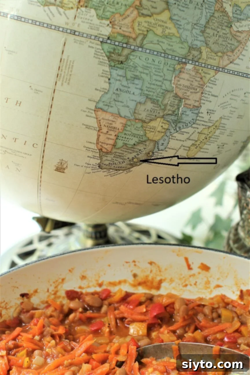 Chakalaka & Pap: Lesotho's Soul Food 3 A dish of colorful Chakalaka stew placed in front of a globe, highlighting the location of Lesotho on the African continent.