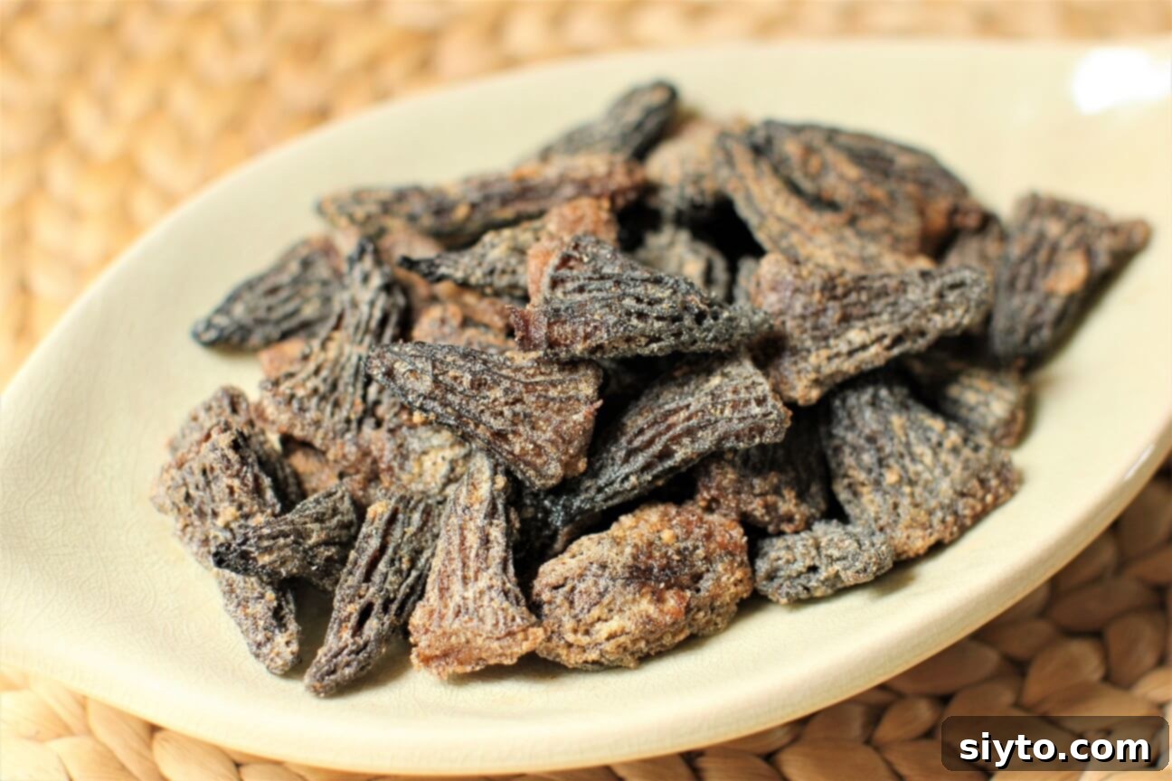 Savory Pan Fried Morel Mushroom Bites 12 A small, elegant plate filled with golden, pan-fried morel mushrooms, ready to be served as a gourmet snack or appetizer