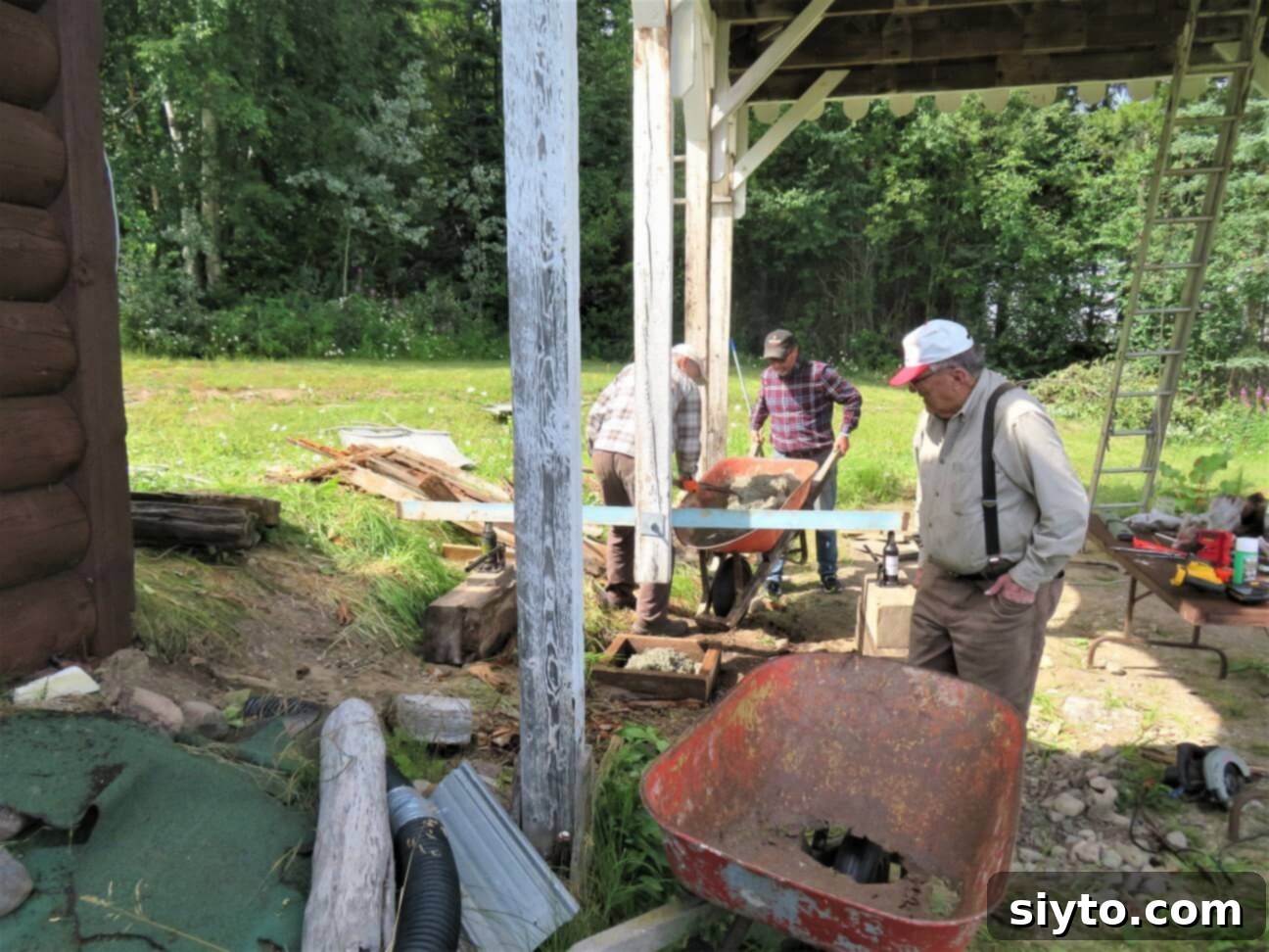 Men working diligently with neighbor Dave to re-cement the posts of the outdoor port, demonstrating communal effort.
