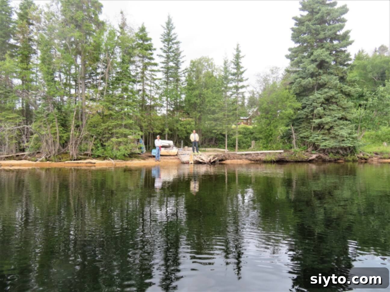 The men waving goodbye from the dock as a fishing boat departs for another excursion on the lake.
