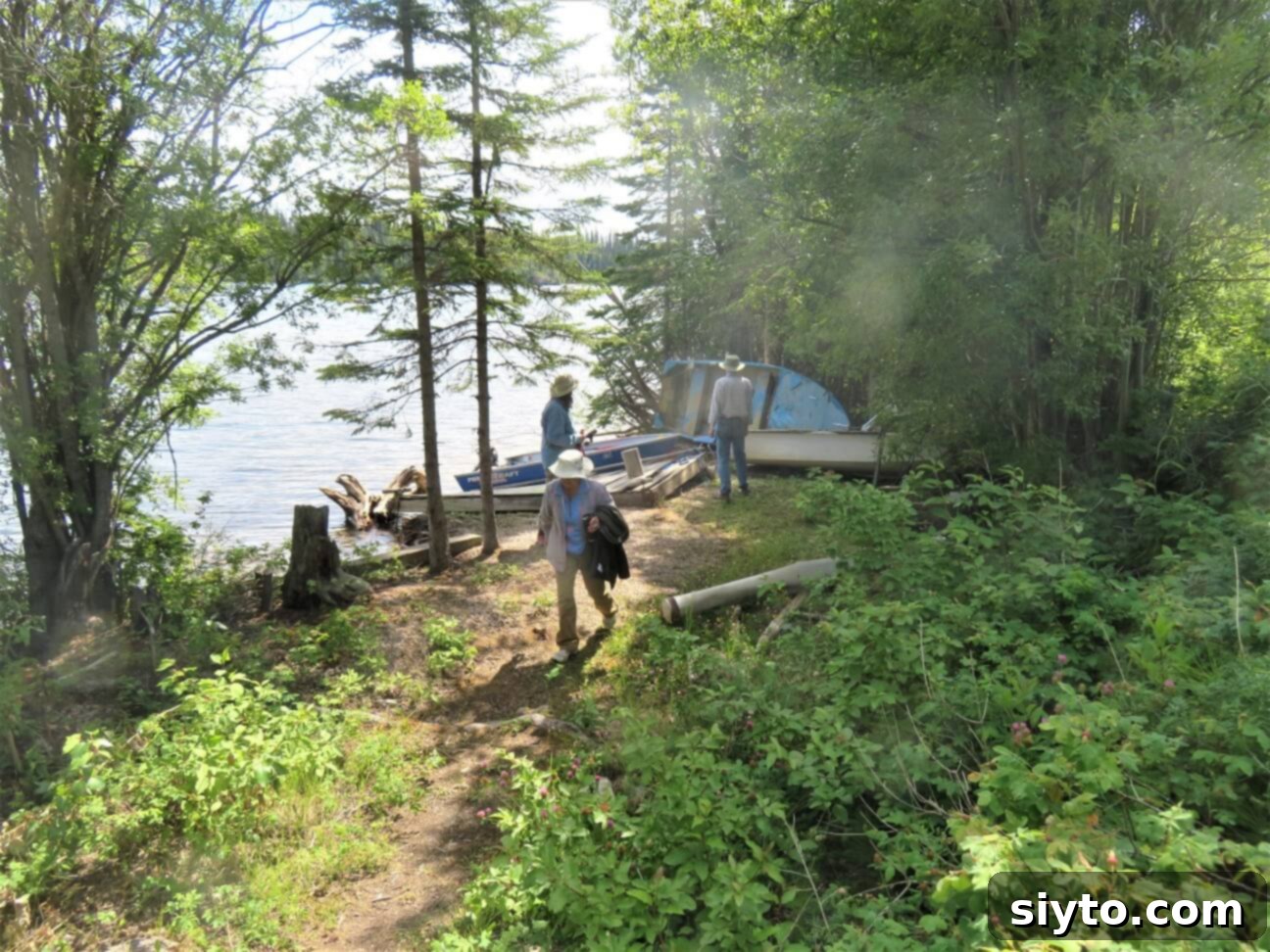 A serene image of people walking up from the lake after a peaceful and successful fishing trip.