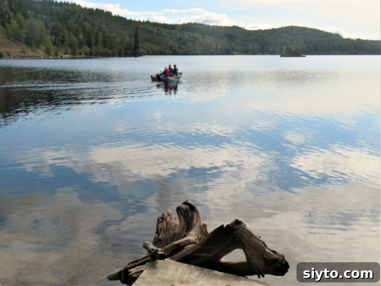 A small fishing boat gliding across the calm lake waters, surrounded by serene natural beauty.