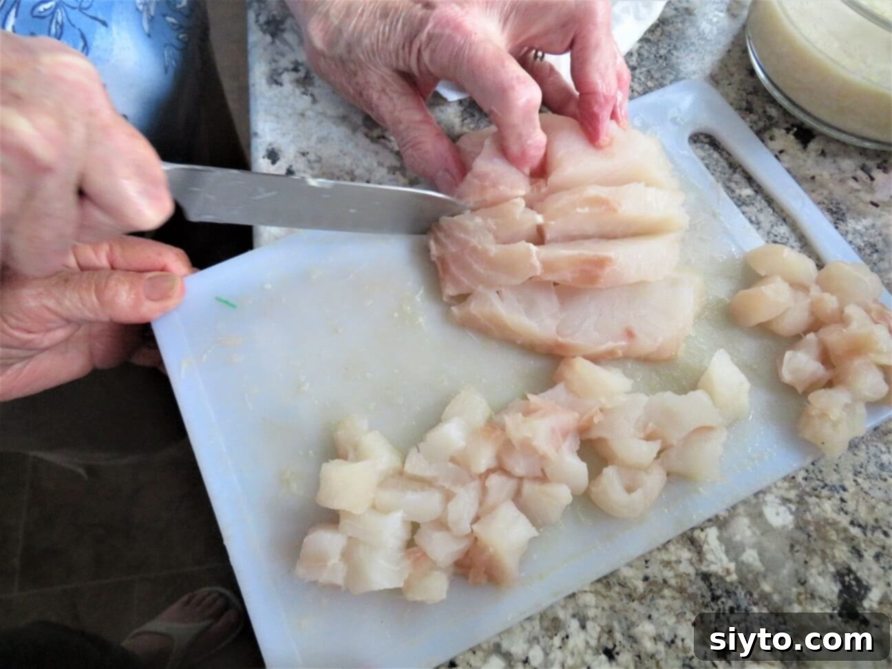 cutting up a piece of halibut
