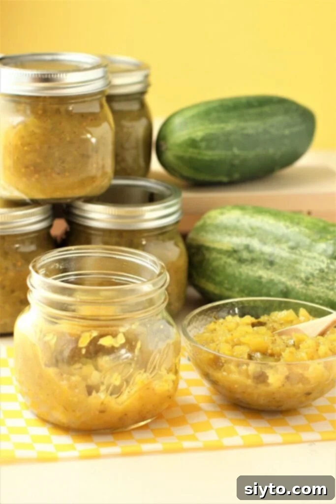 Jars of homemade cucumber relish, a bowl of relish, and two large overripe cucumbers