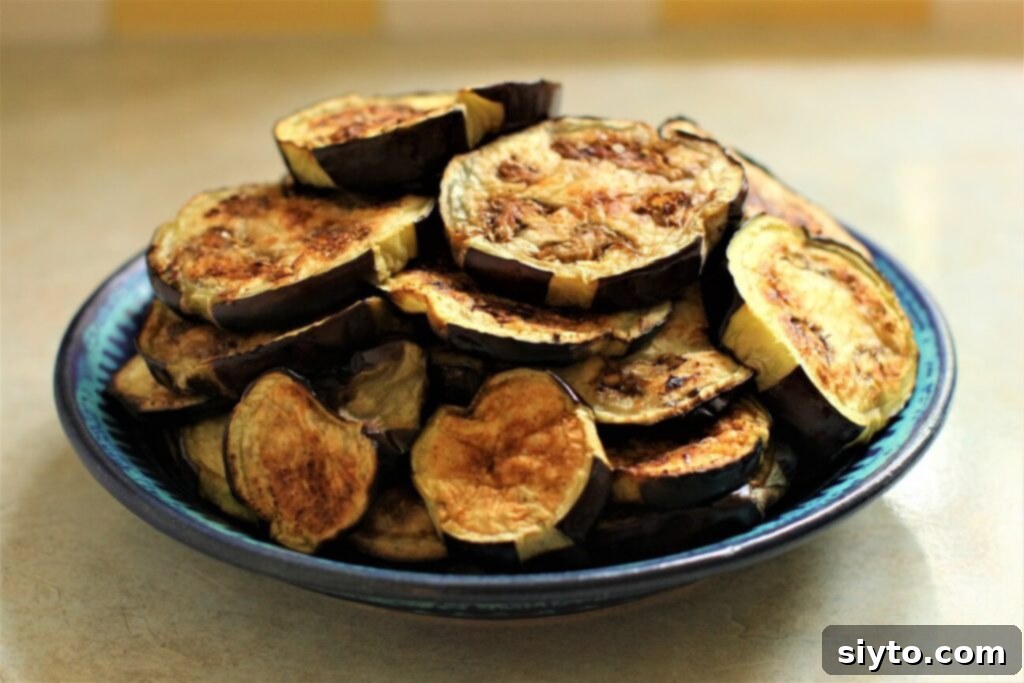 blue plate piled with grilled eggplant slices