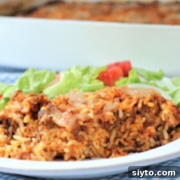 A plated serving of Maltese baked rice, accompanied by a fresh green salad, highlighting a balanced and delicious meal presentation.