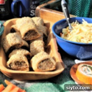 wooden bowl of gluten-free sausage rolls on picnic blanket with other foods
