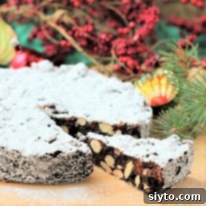 icing dusted panforte cake with a wedge cut and pulled forward