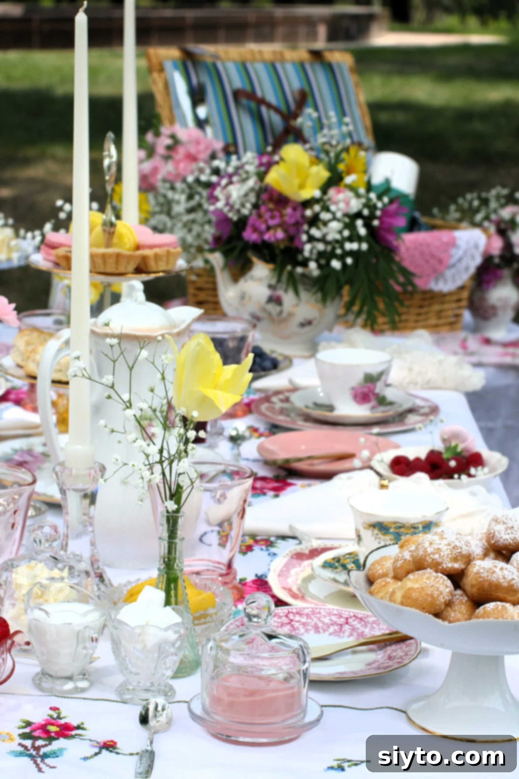 looking down the length of the filled tea table, yellow tulip in single vase.
